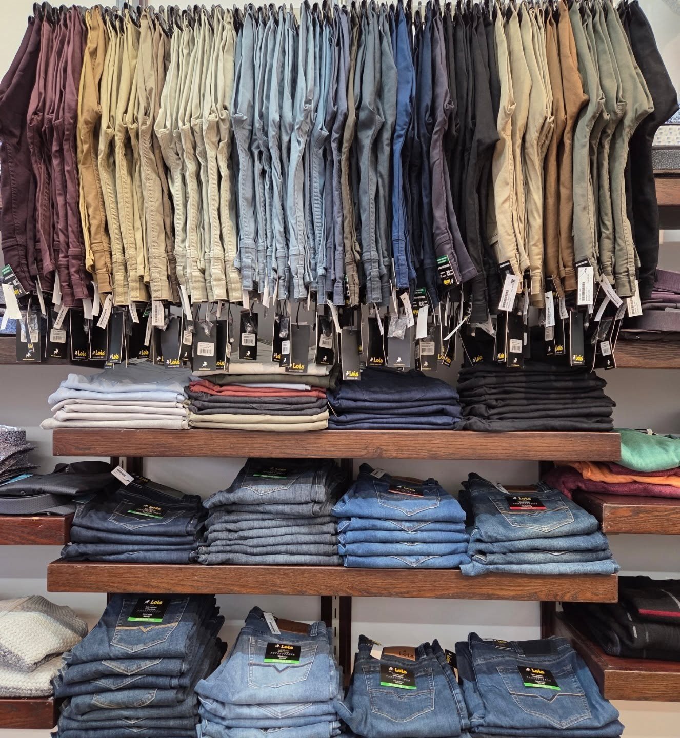Wall of trousers and folded jeans in store at Buragina's